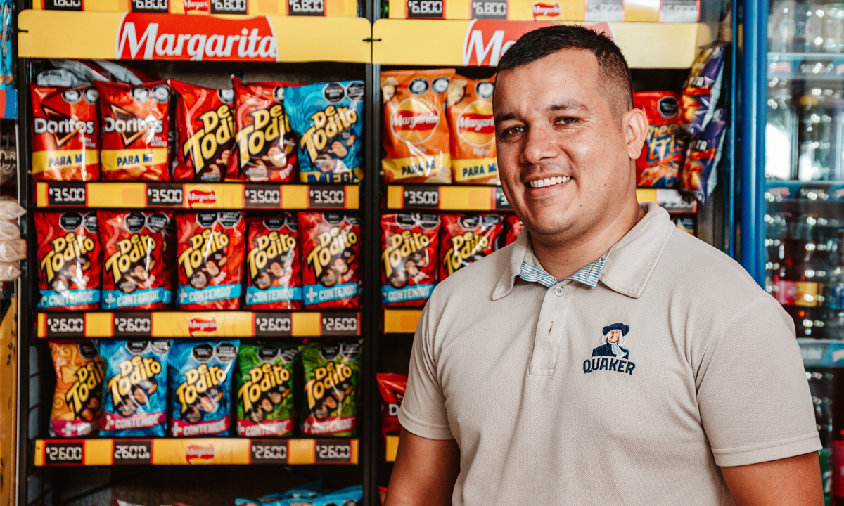 PepsiCo associate smiling next to PepsiCo product displays